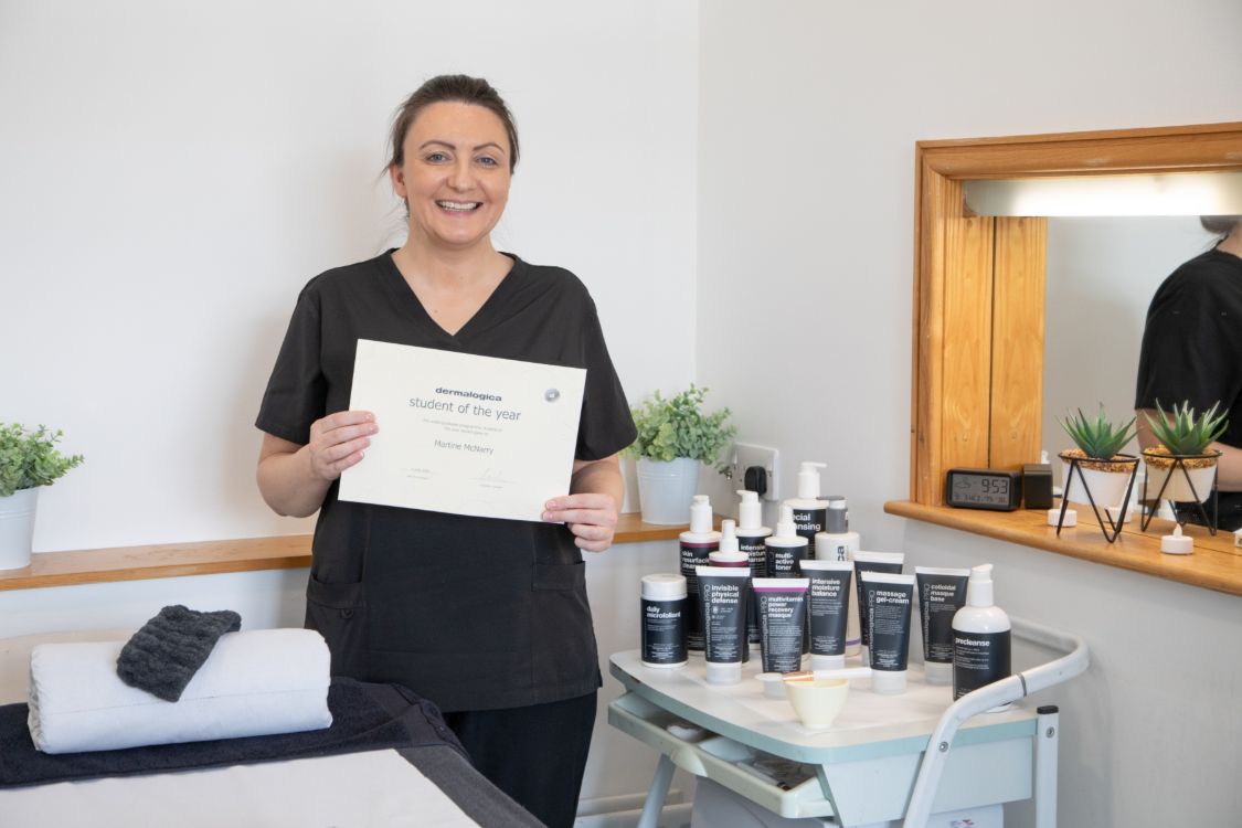 Beauty therapy student Martine McNarry in the salonat SERC Bangor Campus holding her Dermalogica Award certificate